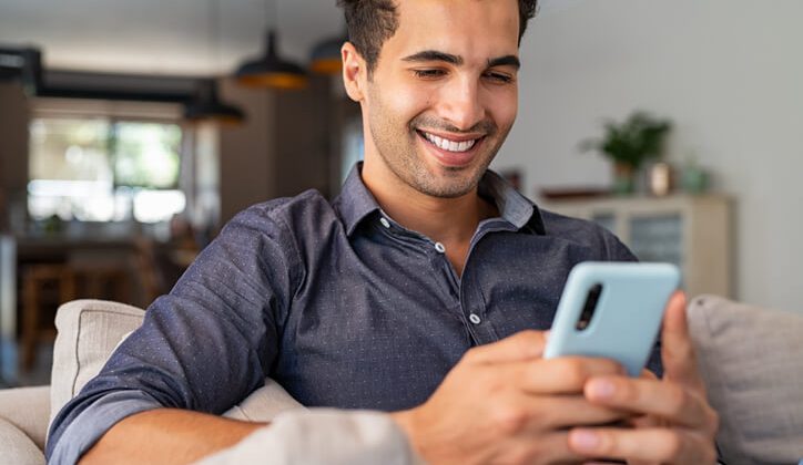 A young guy sending a text message through his phone