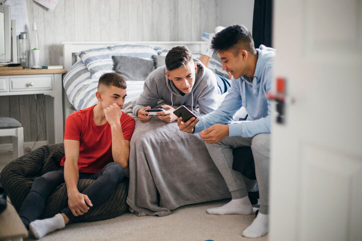 Three young boys searching for the best snapchat alternative in their mobile phones