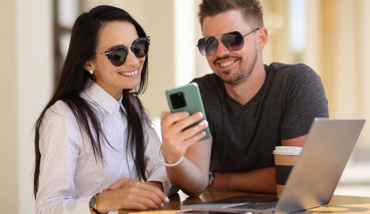 A young couple sending text message through android app