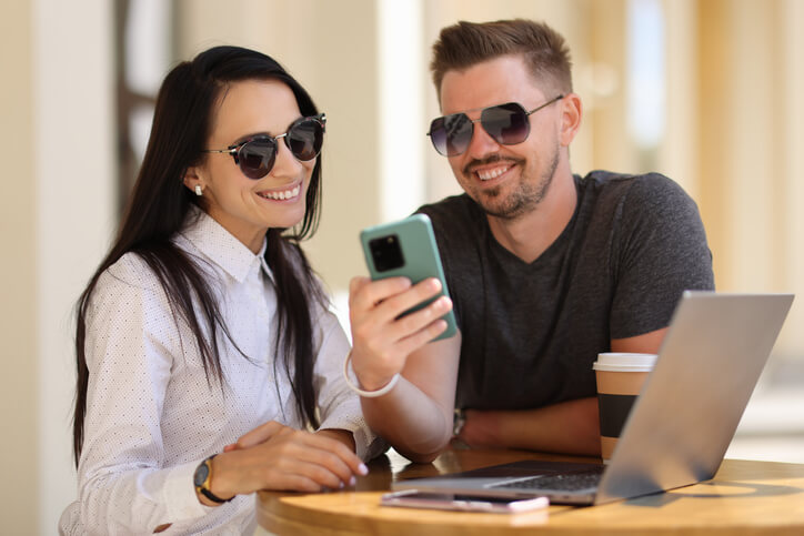 A young couple sending text message through android app