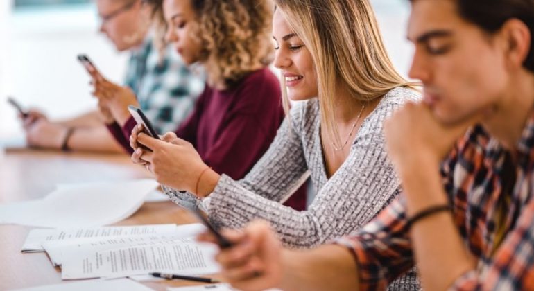 students using mobile phone in class
