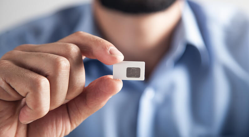 Male hand holding Sim card with sim only deals package