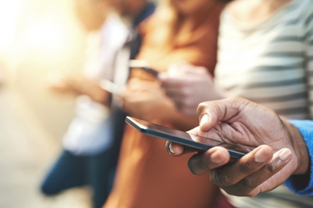 Shot of an unrecognizable group of people social networking outside phone contract bad credit
